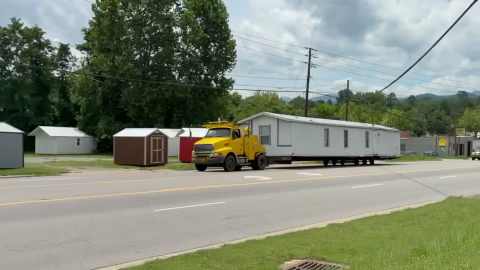 Our truck pulling a single-wide past the shops. Built by Asheville Modular and Mobile Home Services.